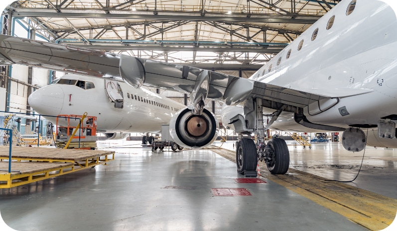 Two stationary aeroplanes in an aircraft hanger.