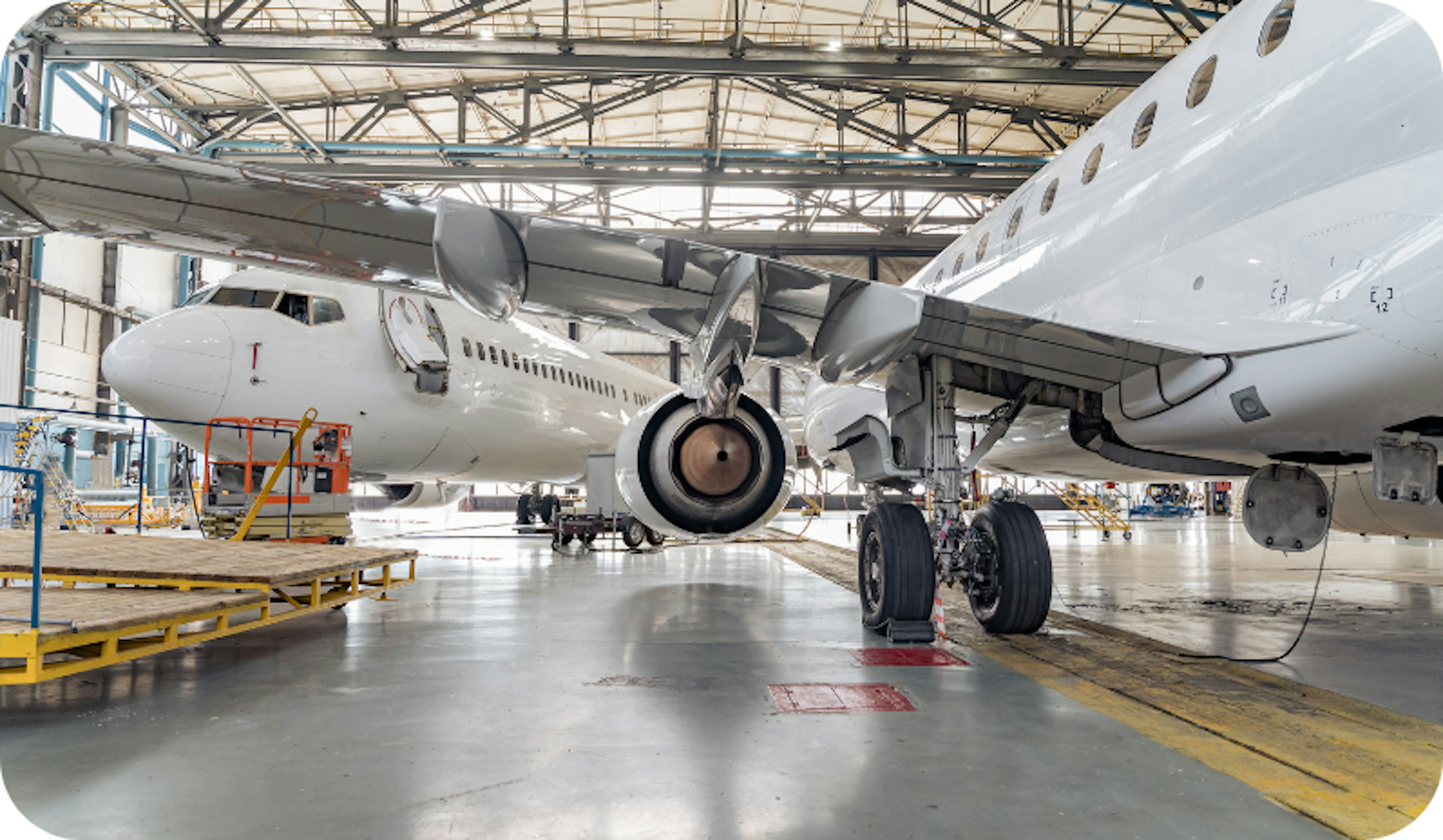 Two stationary aeroplanes in an aircraft hanger.