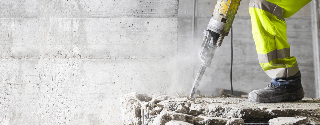 Worker using vibrating power tool highlighting hand–arm vibration exposure risk