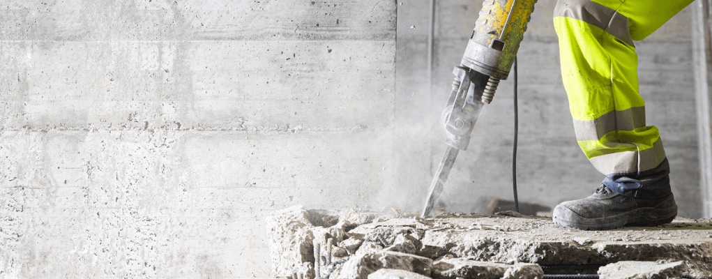 Worker using vibrating power tool highlighting hand–arm vibration exposure risk