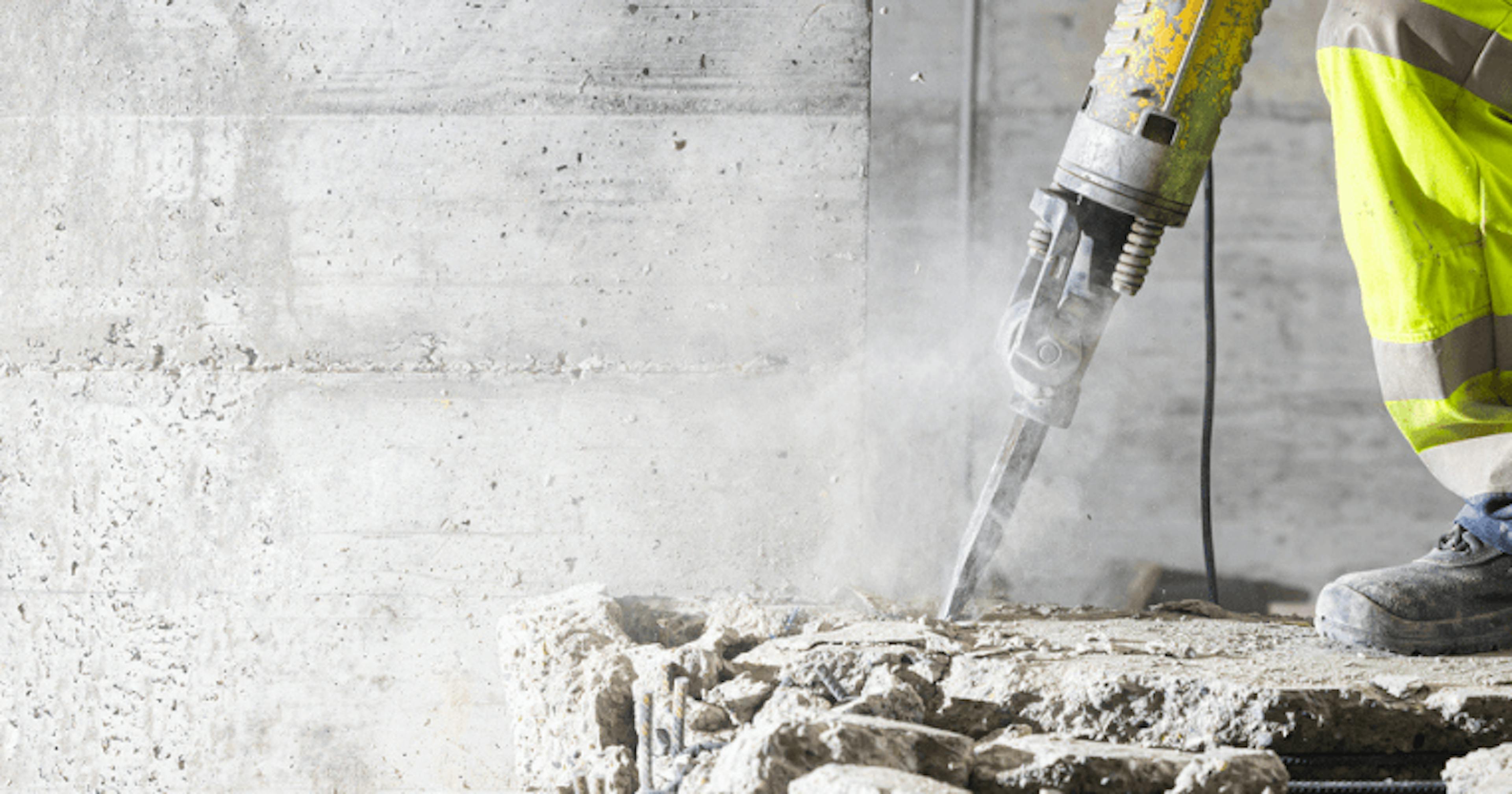 Worker using vibrating power tool highlighting hand–arm vibration exposure risk