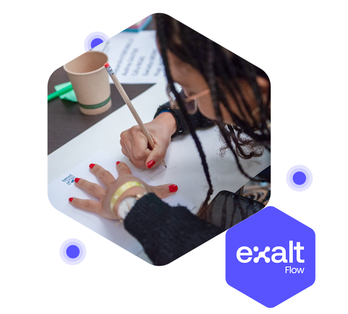 Una persona dibujando en una hoja de papel, con el logo de eXalt Flow a su lado.