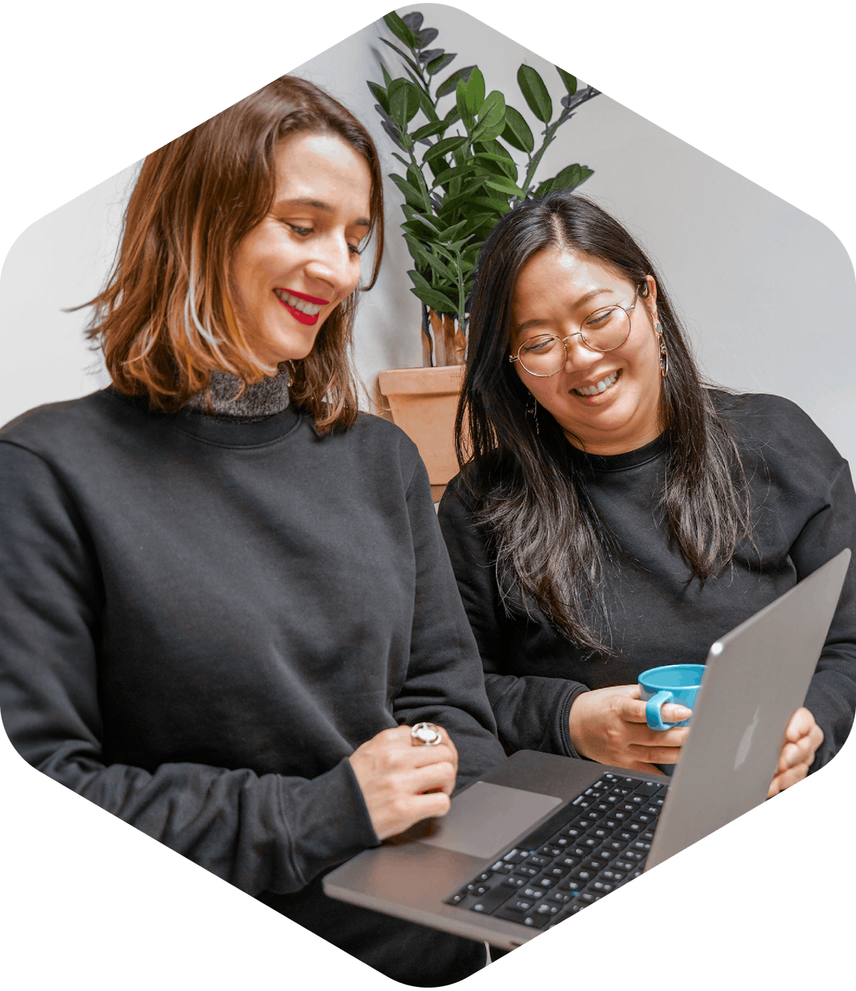 Two people smiling while looking at information on a computer.