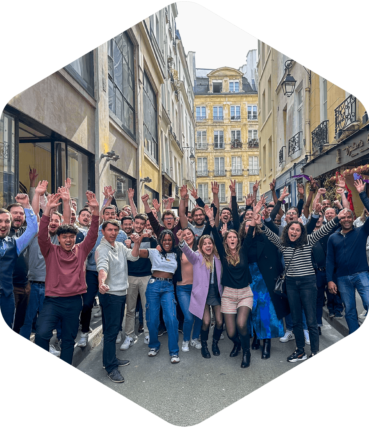 Un groupe de personnes posant joyeusement dans la rue devant les locaux d'exalt.