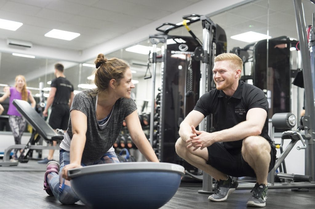Man with personal trainer in gym