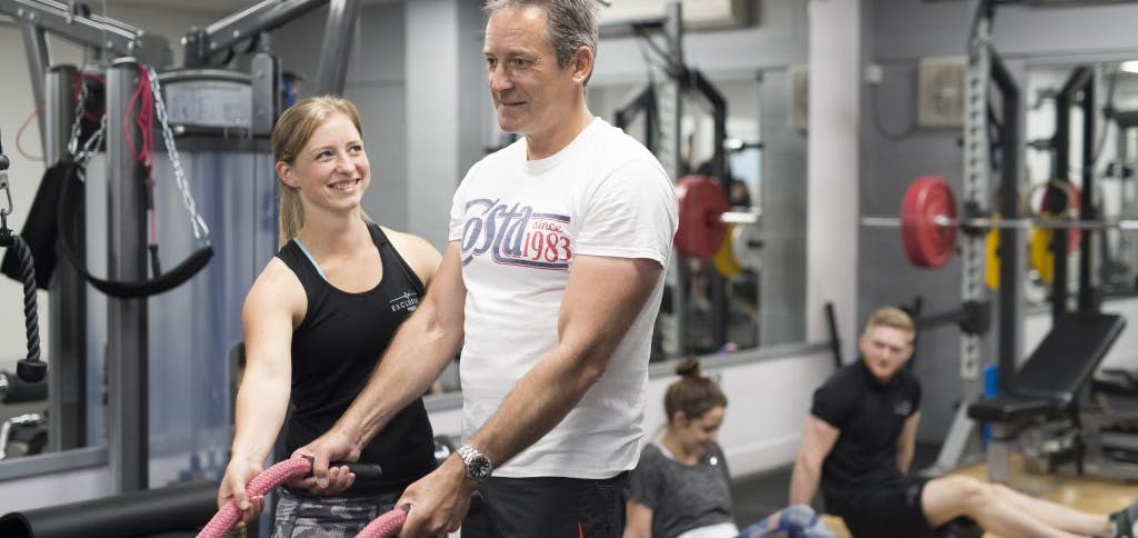 Personal trainer with client in Gym