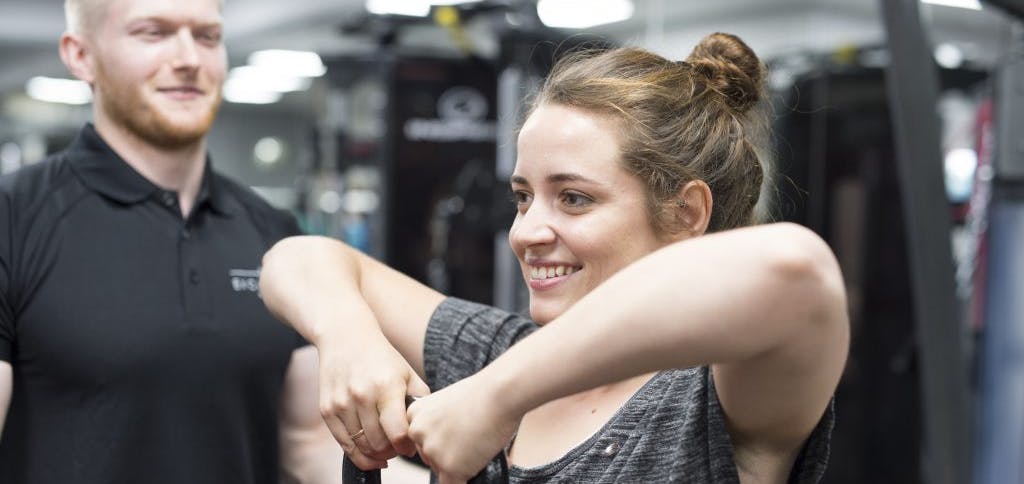 A young girl lifting a kettle bell