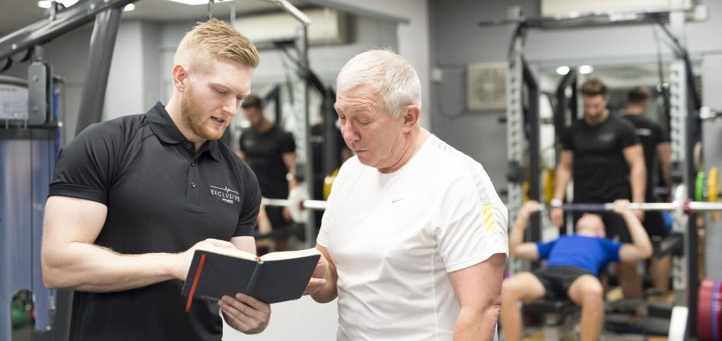 An Exclusive Fitness trainer talking through plans with a client.