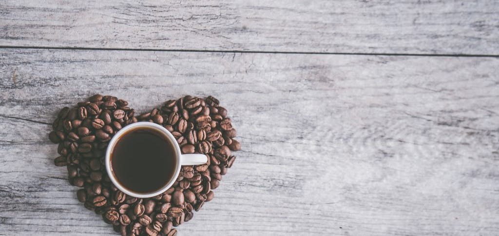 Coffee cup surrounded by coffee beans