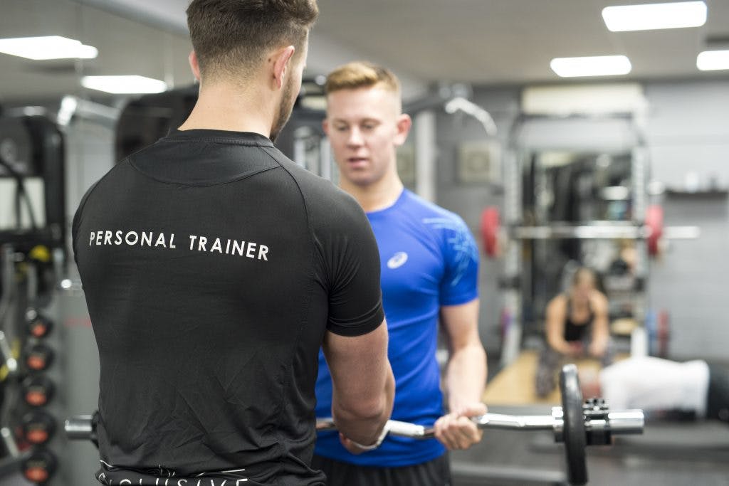 Man with personal trainer in gym