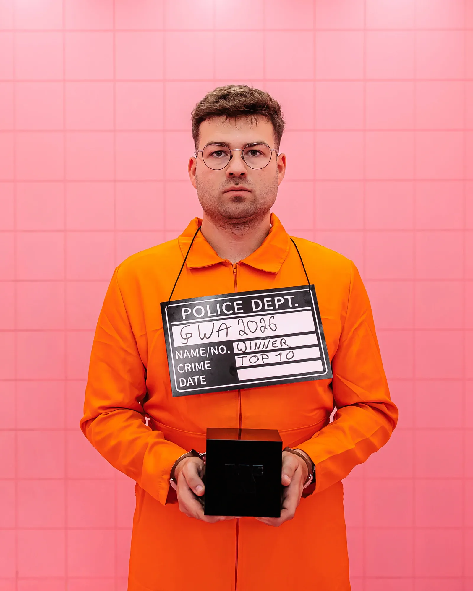 Webentwickler steht in einem orangefarbenen Anzug in einer pinken Zelle