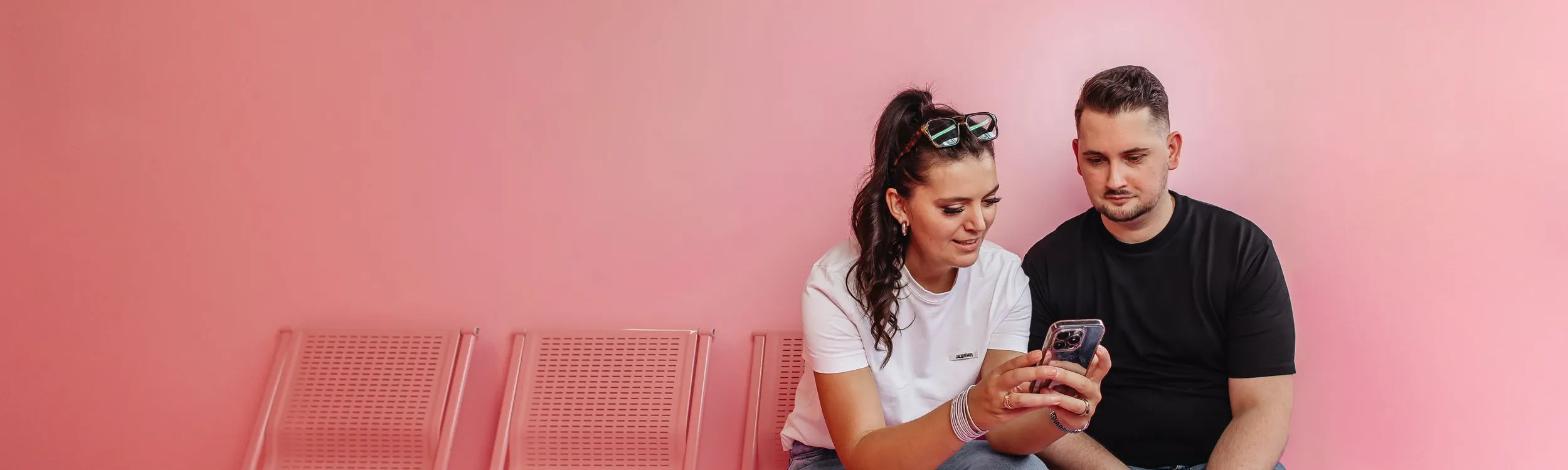 Zwei Mitarbeiter der Social Recruiting Agentur Exportarts auf einer pinken Wand