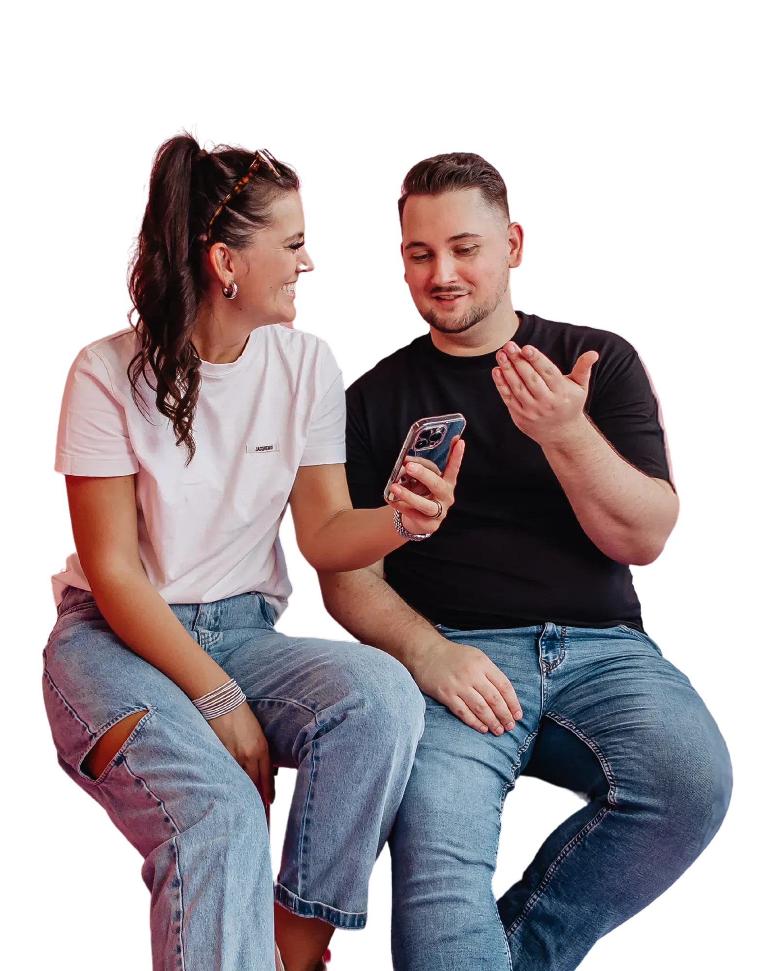 Zwei Personen sitzen mit einem iPhone auf einer pinken Bank