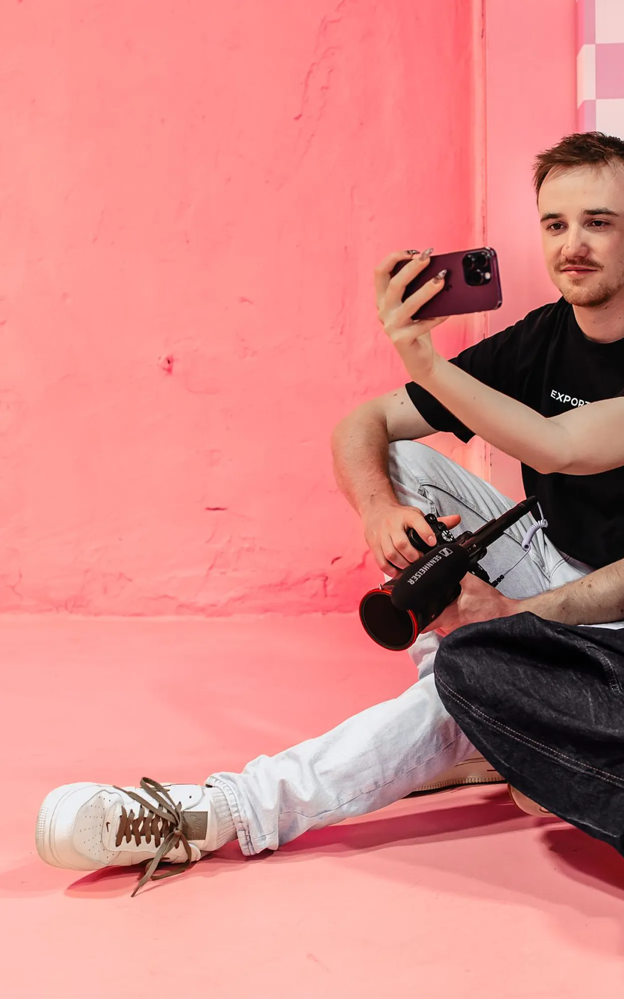 Zwei Mitarbeiter der Kasseler Social Media Agentur Exportarts machen ein Selfie vor einer pinken Wand
