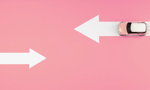 Auto auf weißen Pfeilen auf pinkem Hintergrund Auto auf weißen Pfeilen auf pinkem Hintergrund