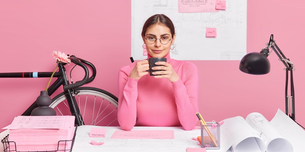 Frau sitzt in pinkem Büro Frau sitzt in pinkem Büro