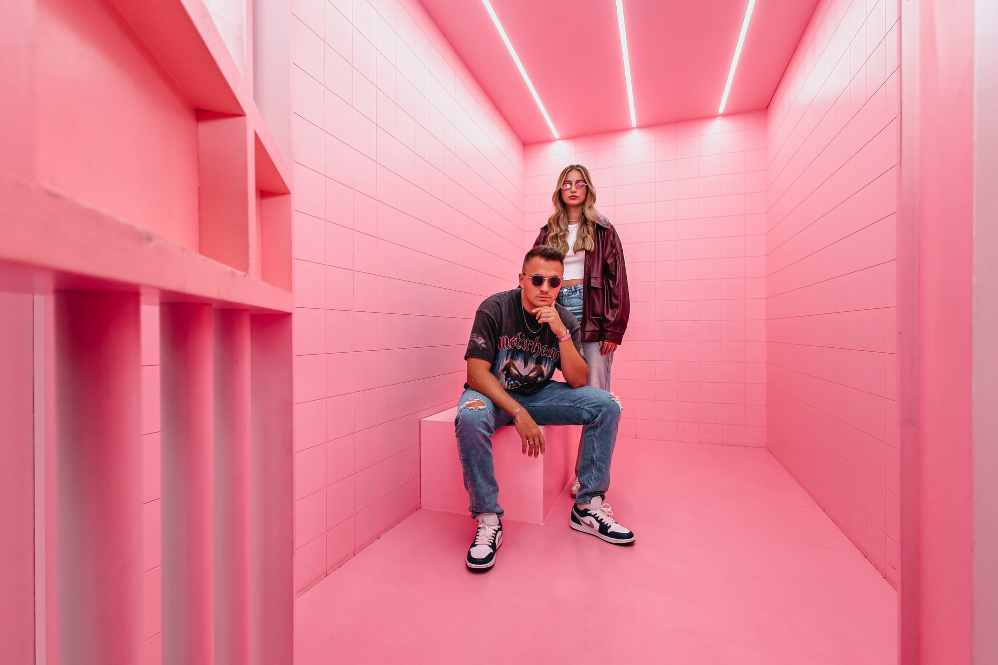 Zwei Personen stehen in futuristisch pinkem Raum – Sinnbild für digitale Sichtbarkeit, KI-Relevanz und starke Positionierung durch GEO-Strategie.