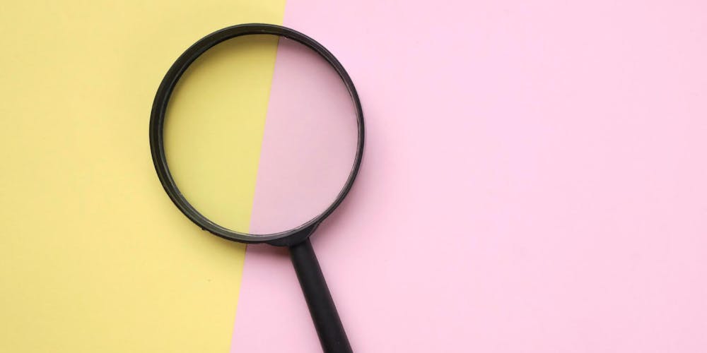 Schwarze Lupe auf zweifarbigem Hintergrund in Pastellgelb und Rosa – Symbolbild für B2B SEO, Analyse oder Recherche. Schwarze Lupe auf zweifarbigem Hintergrund in Pastellgelb und Rosa – Symbolbild für B2B SEO, Analyse oder Recherche.
