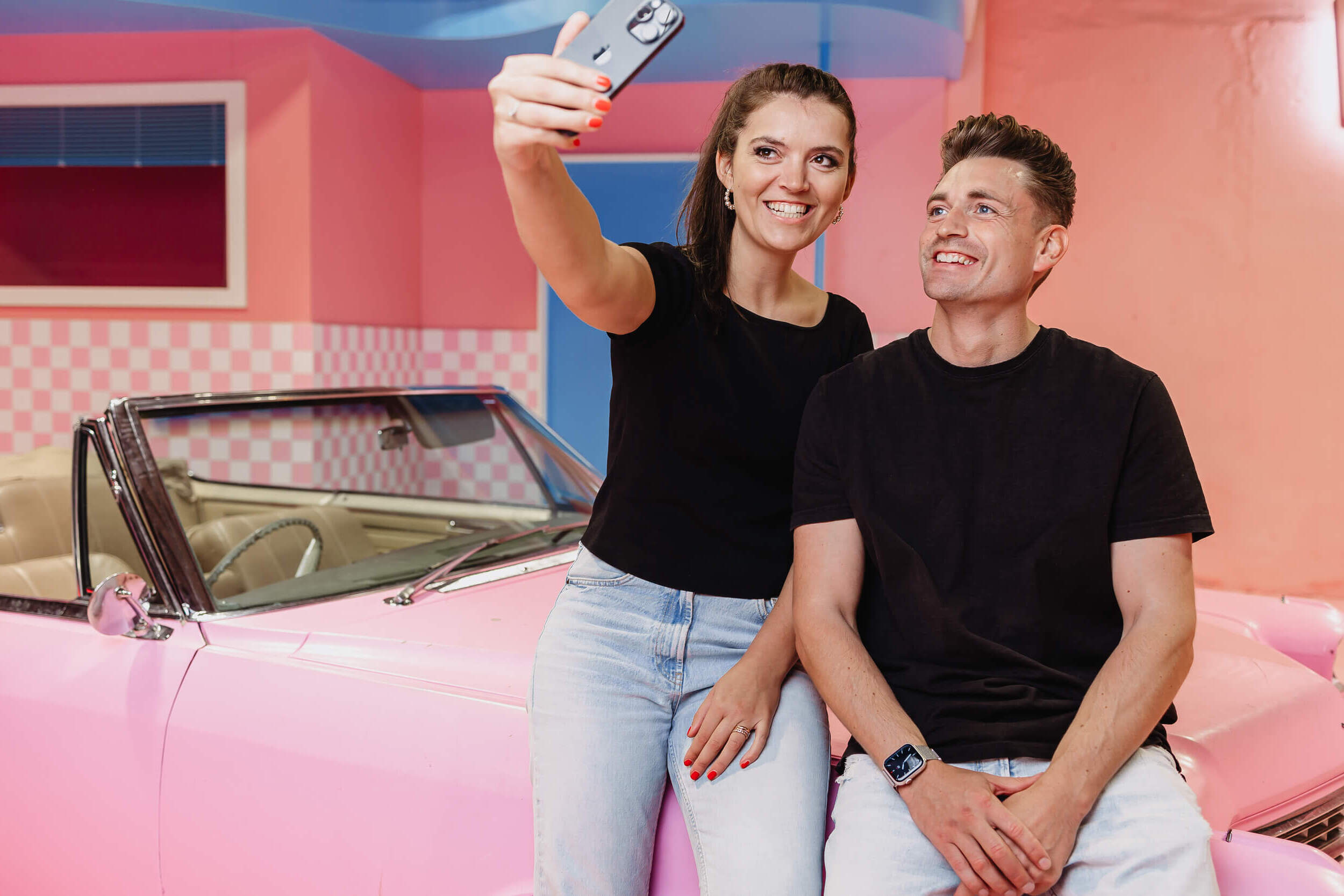 Zwei Social Media Manager machen ein Selfie in einer pinken Umgebung