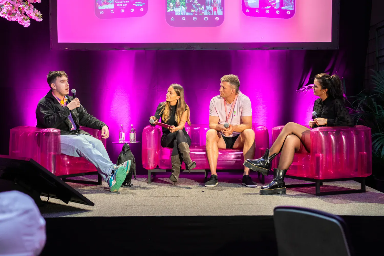 Panel-Talk mit vier Personen auf pinken Sesseln auf der Eventbühne