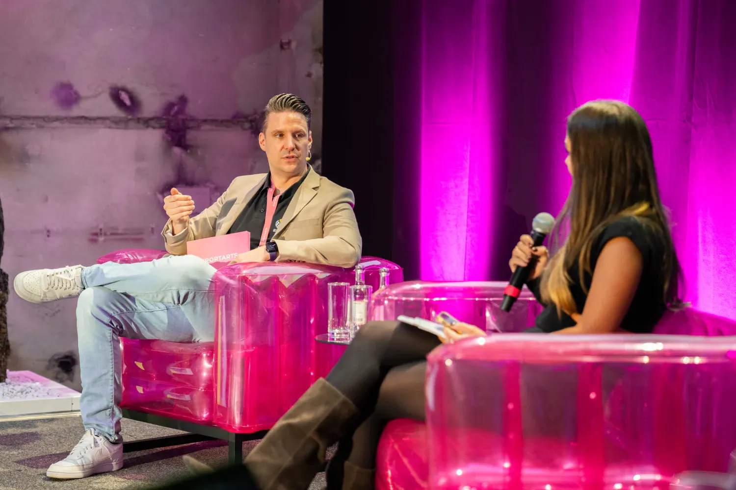 Panel-Talk auf pinken aufblasbaren Sesseln mit Speaker und Moderatorin im Gespräch