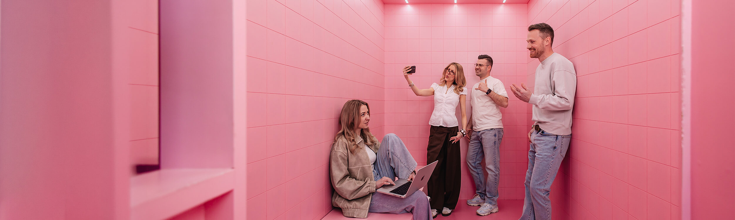 GEO Team bestehend aus SEO Experten und DEV Team in einem pinken Raum