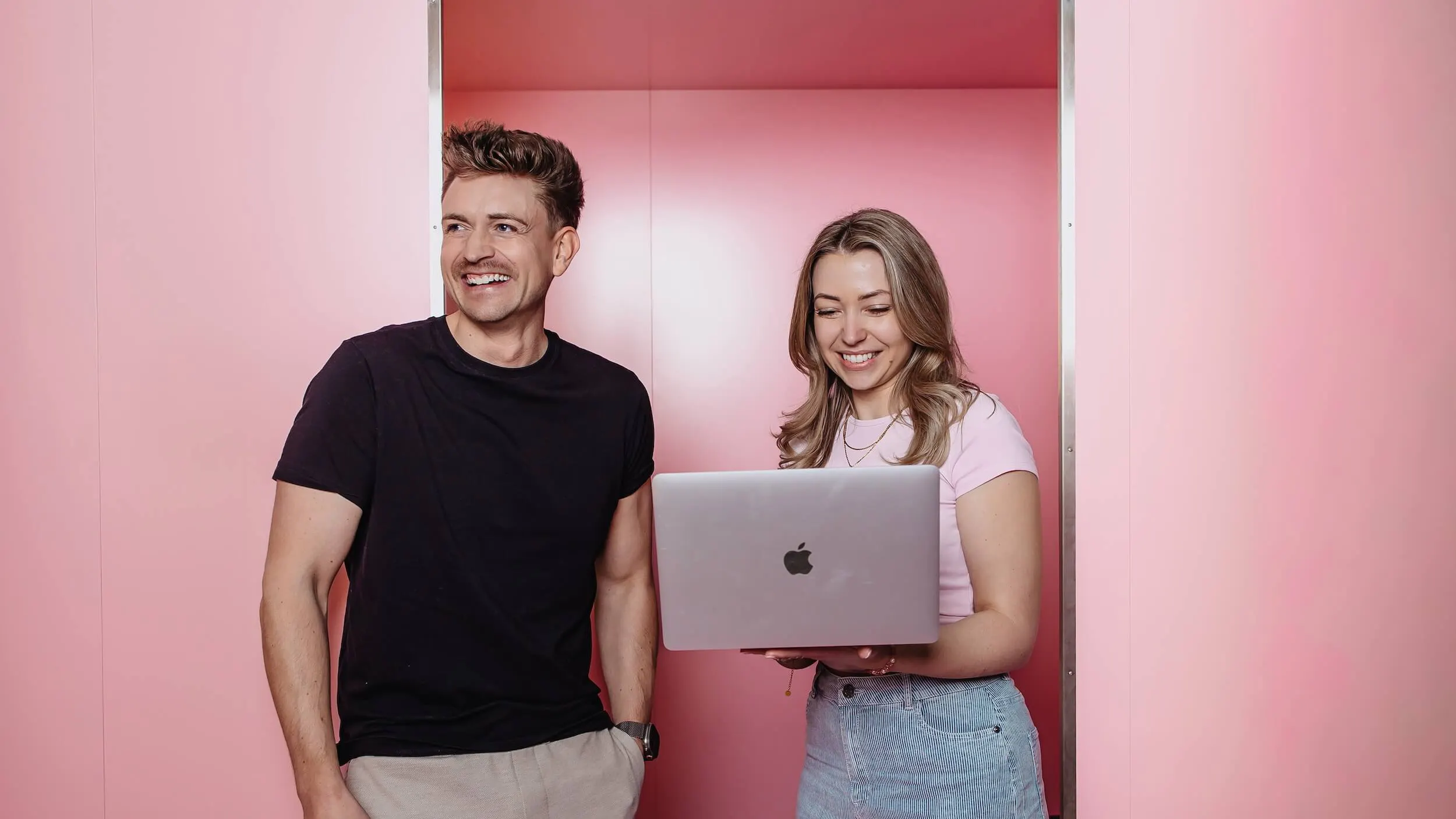 Christoph und Mandana von der SEO Agentur Exportarts vor einer pinken Wand