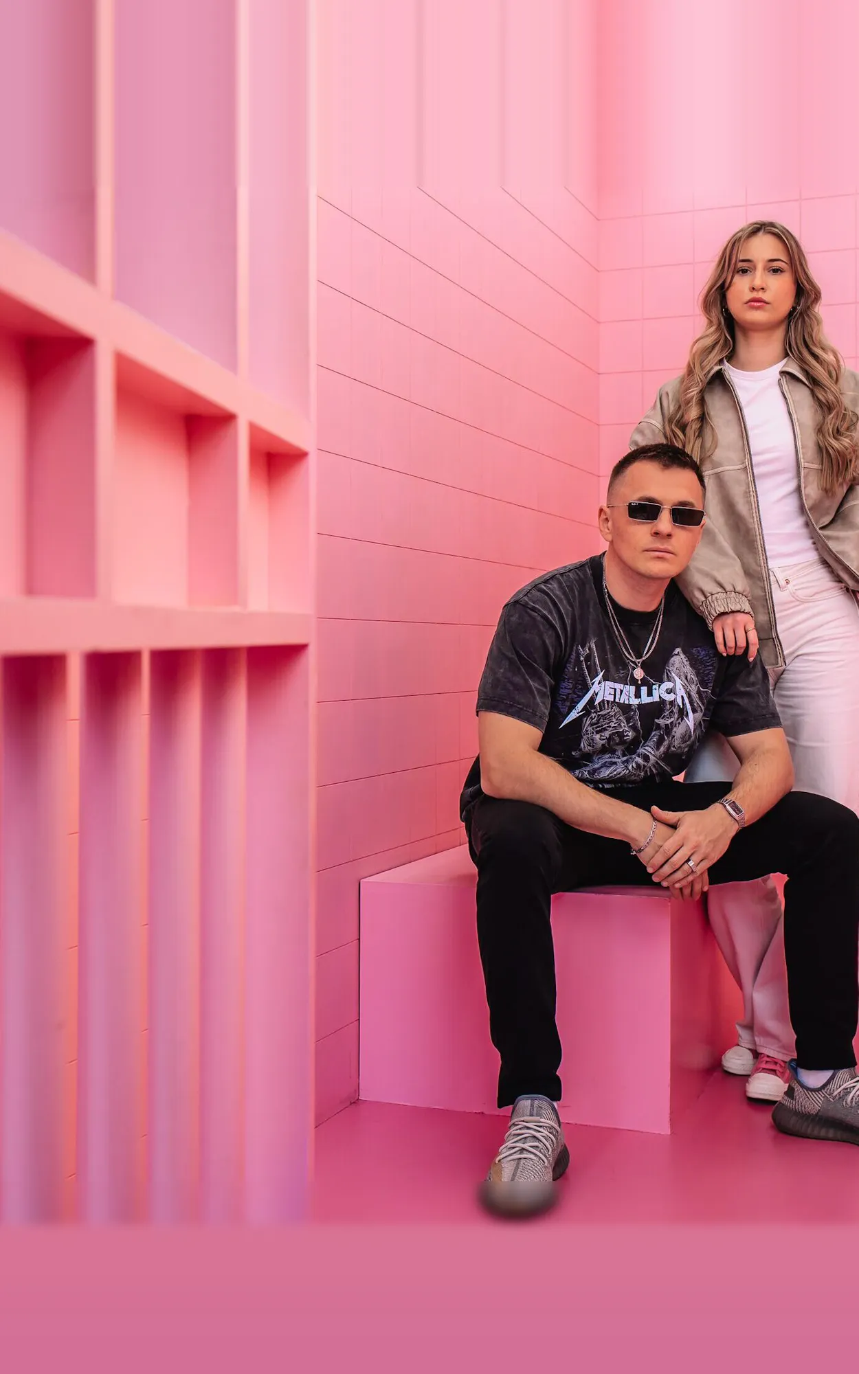 Team der GEO Agentur Exportarts – zwei Personen mit Sonnenbrille vor pinkfarbener Kulisse
