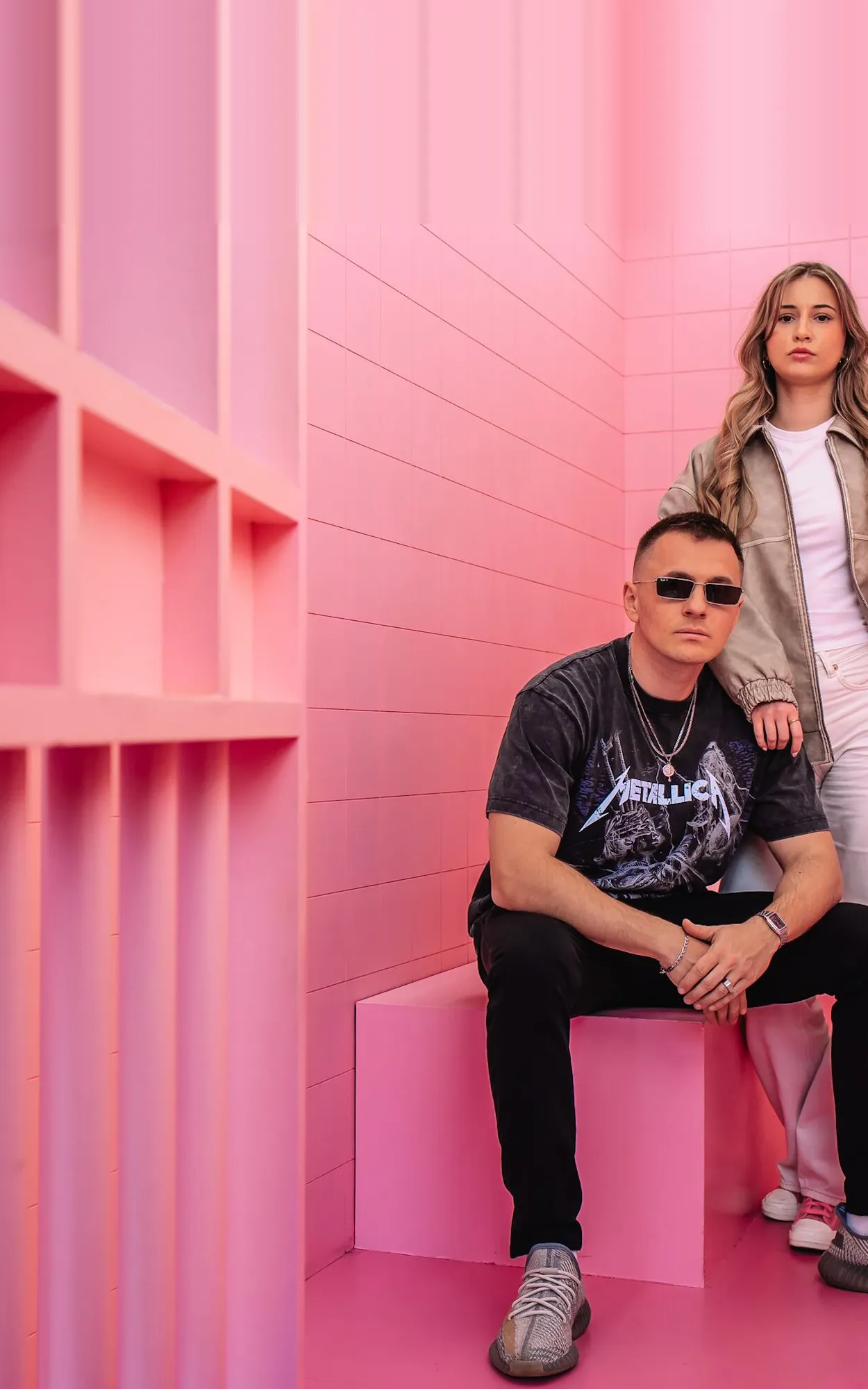 Team der GEO Agentur Exportarts – zwei Personen mit Sonnenbrille vor pinkfarbener Kulisse