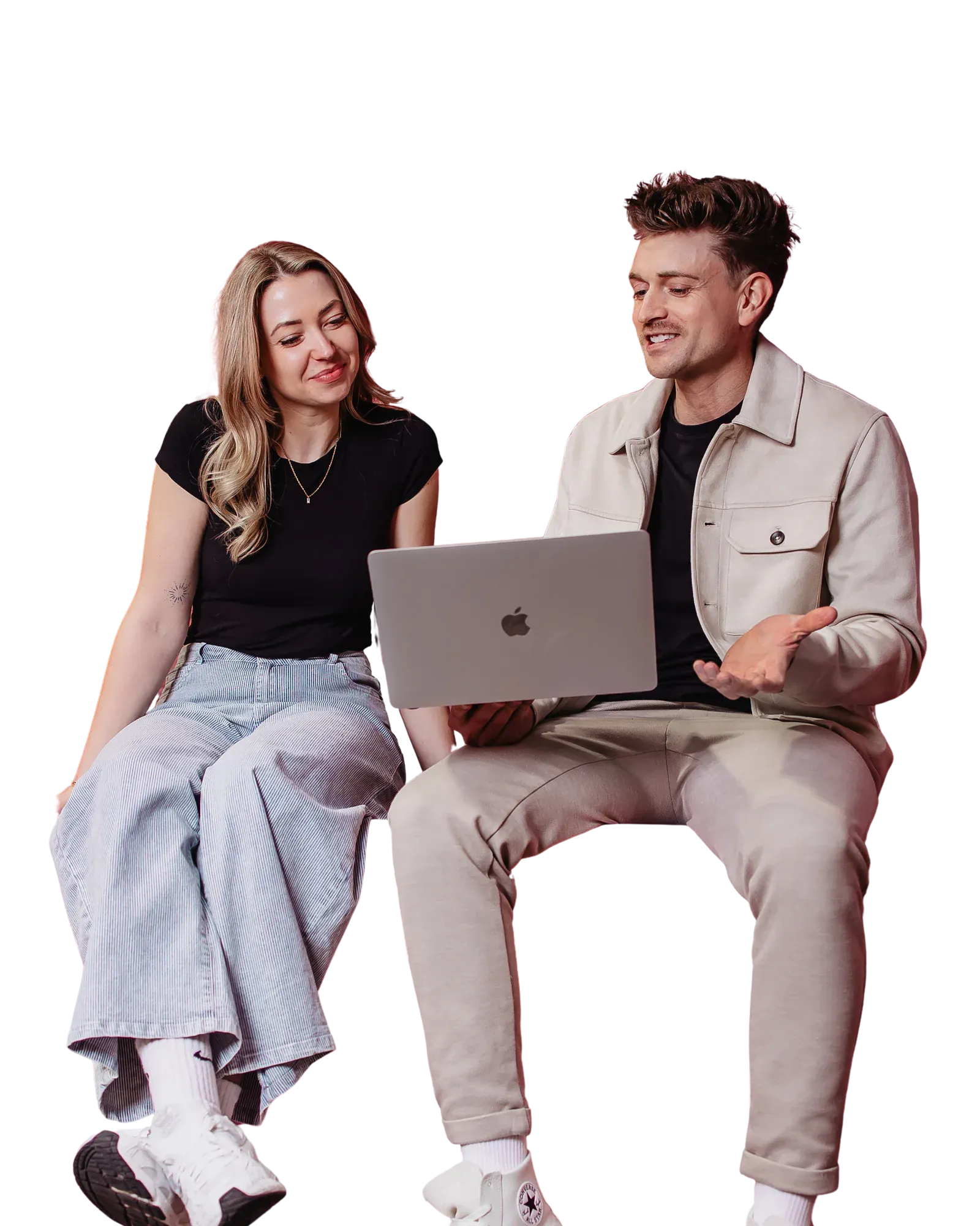 Zwei Mitarbeiter der Online Marketing Agentur Exportarts sitzen mit einem Macbook auf einer pinken Theke 