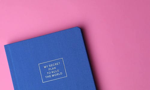 Blaues Notizbuch auf pinkem Hintergrund Blaues Notizbuch auf pinkem Hintergrund