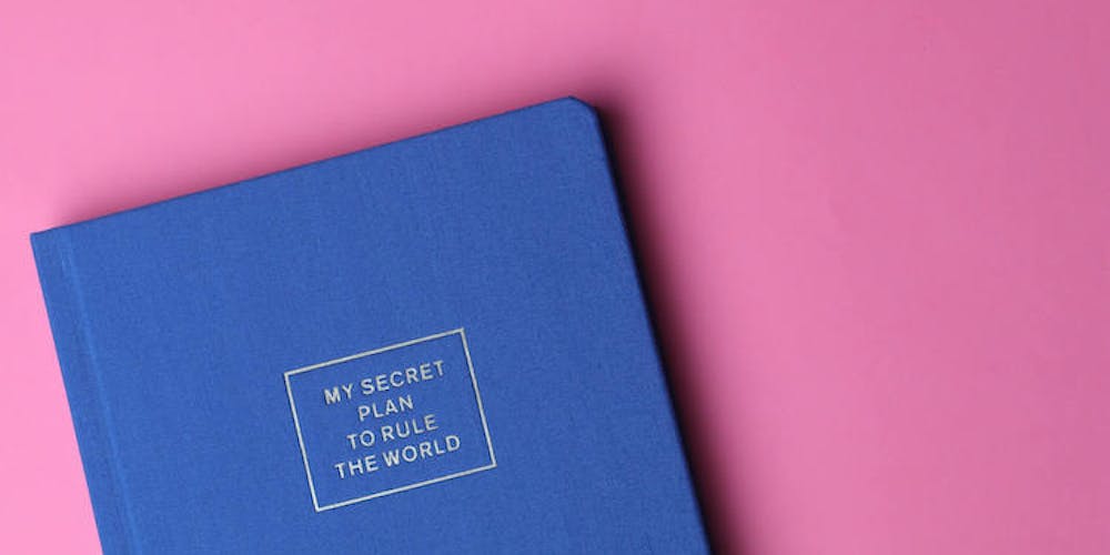 Blaues Notizbuch auf pinkem Hintergrund Blaues Notizbuch auf pinkem Hintergrund