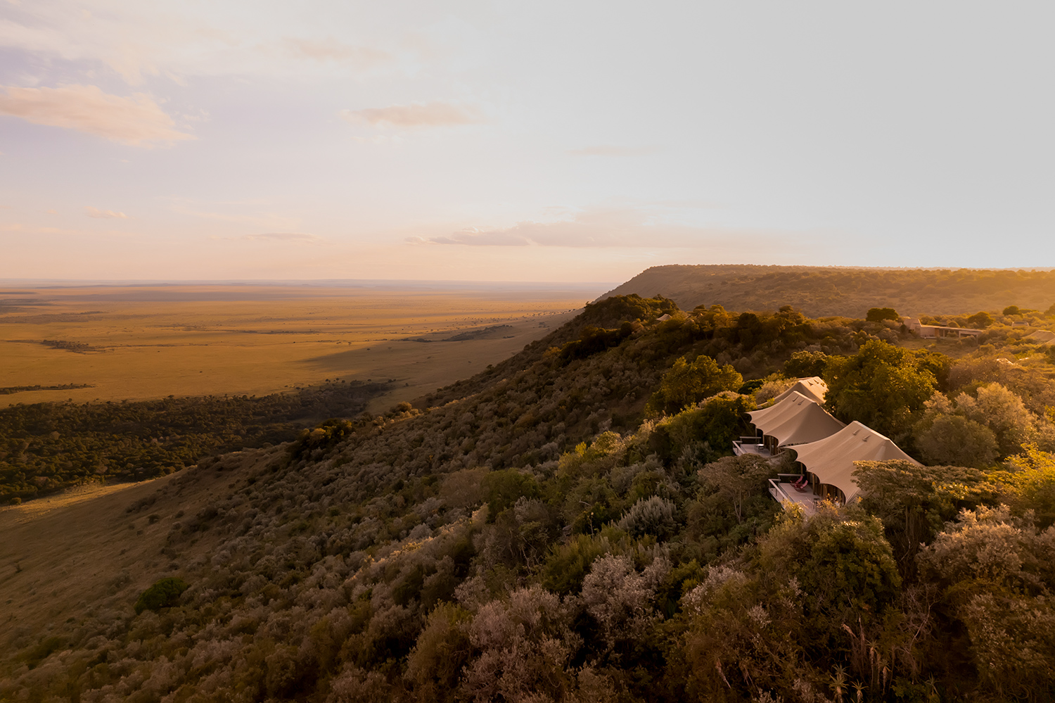 Aerial view luxury tented camp overlooking Maasai Mara plains, Kenya