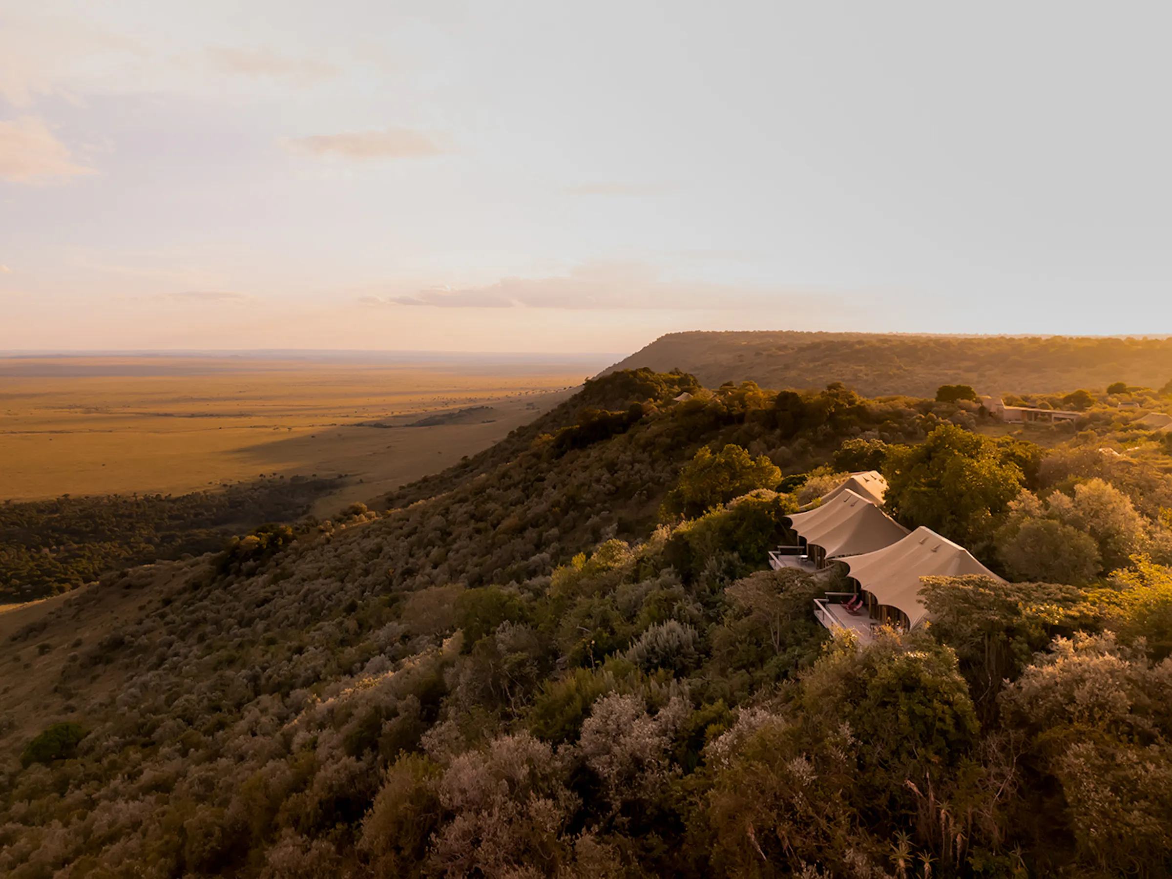 Aerial view luxury tented camp overlooking Maasai Mara plains, Kenya
