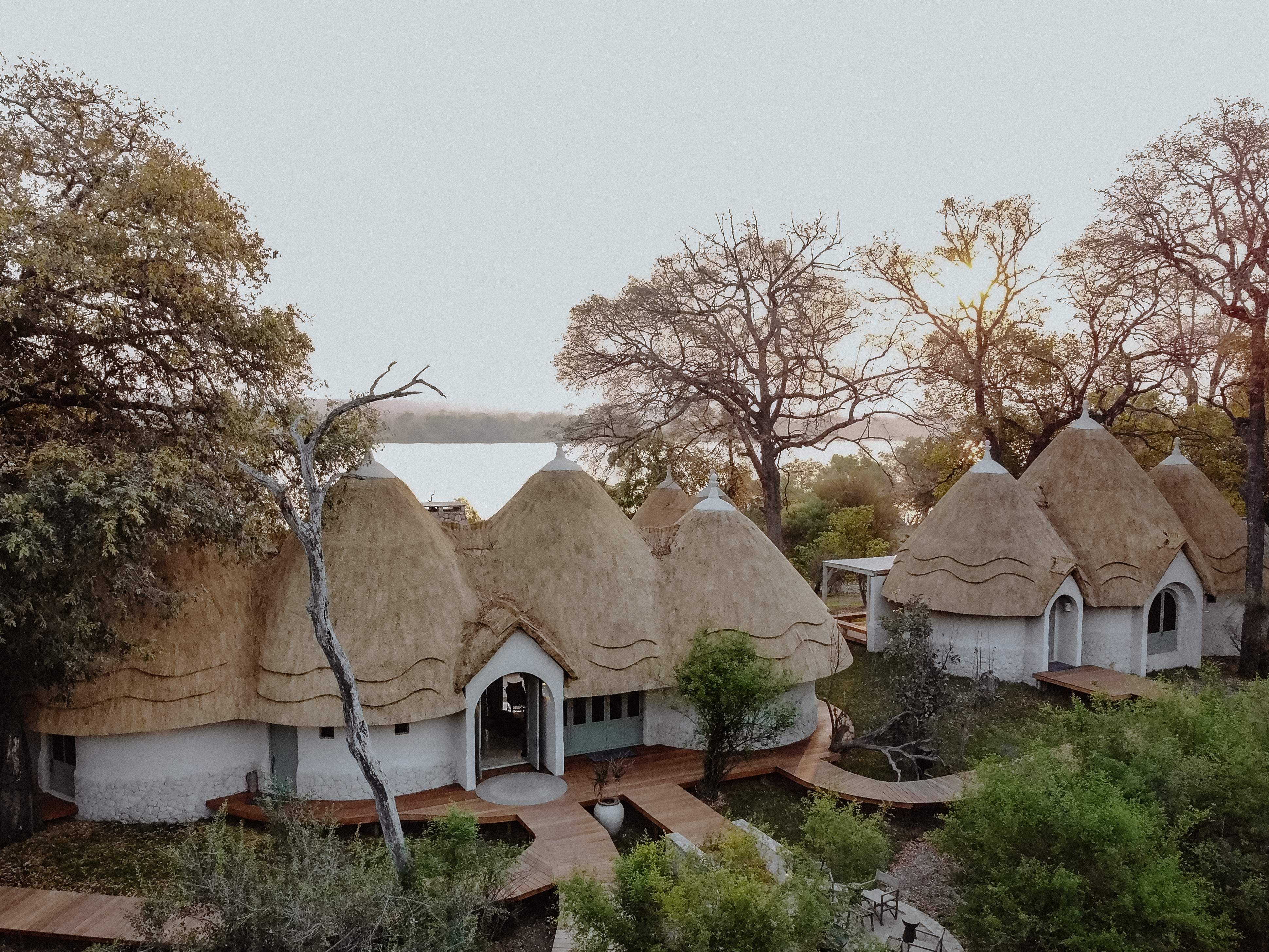Thatched luxury lodge villas with timber walkways, Zambia riverfront