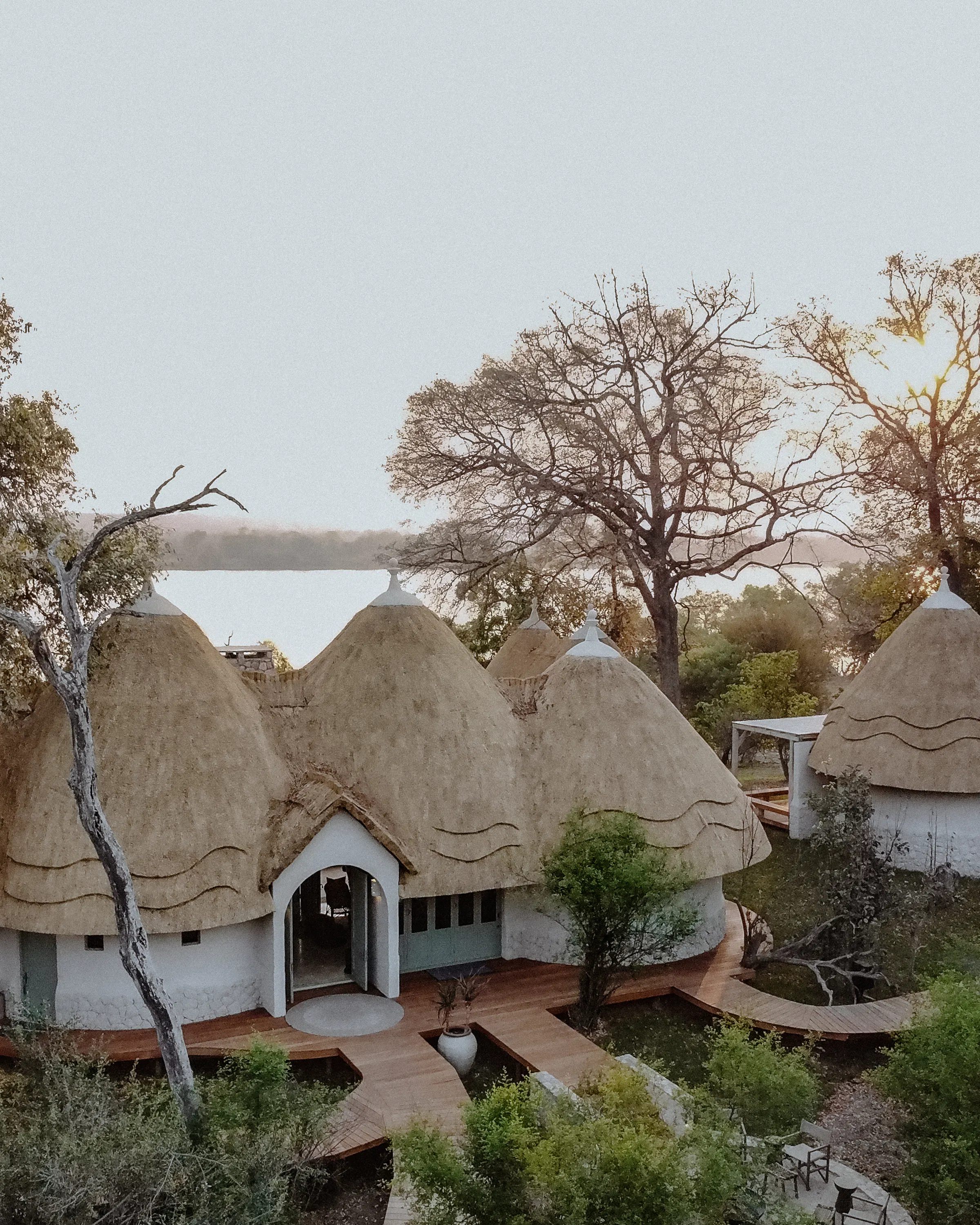 Thatched luxury lodge villas with timber walkways, Zambia riverfront