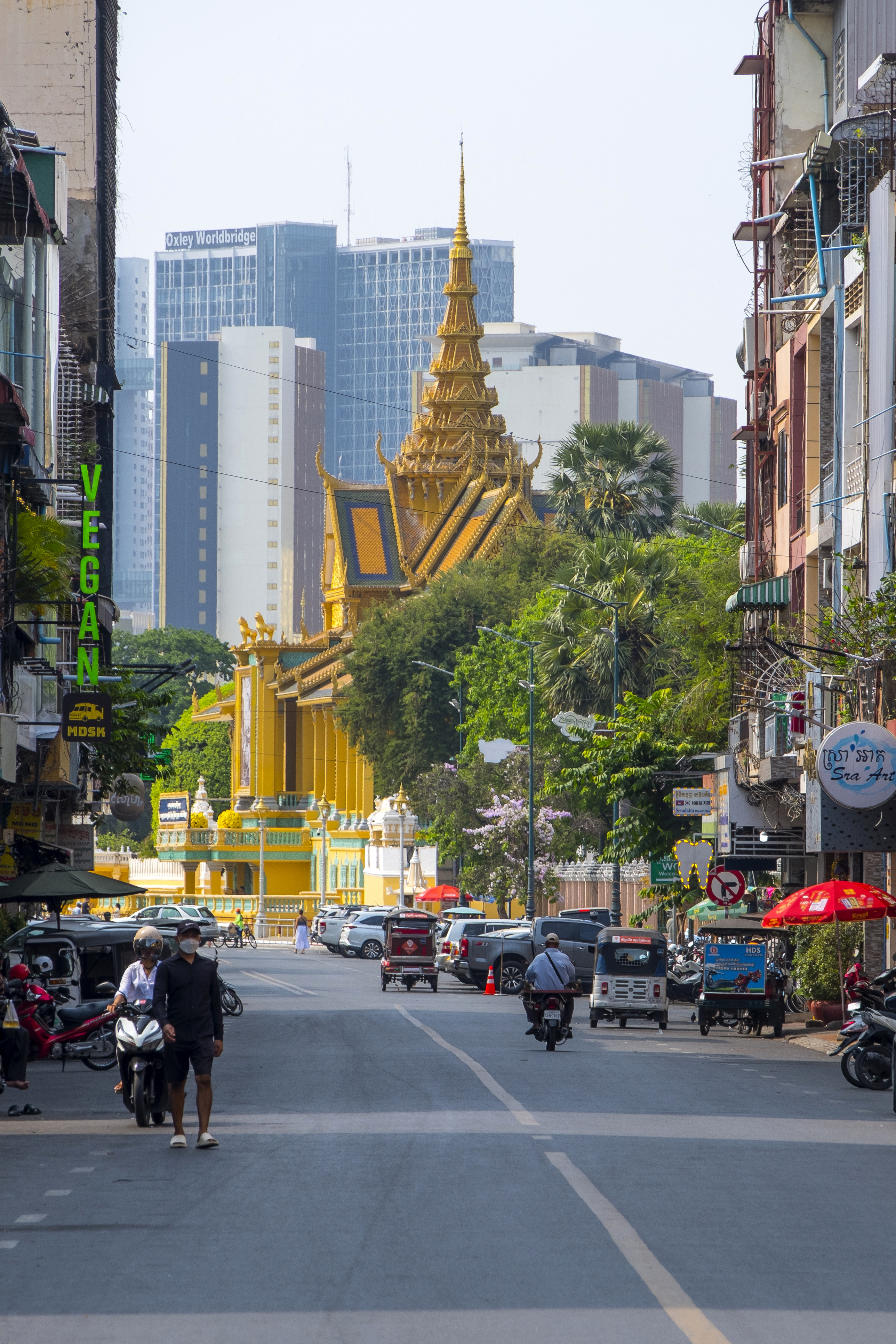 Bustling street with golden Royal Palace spire, Phnom Penh Cambodia