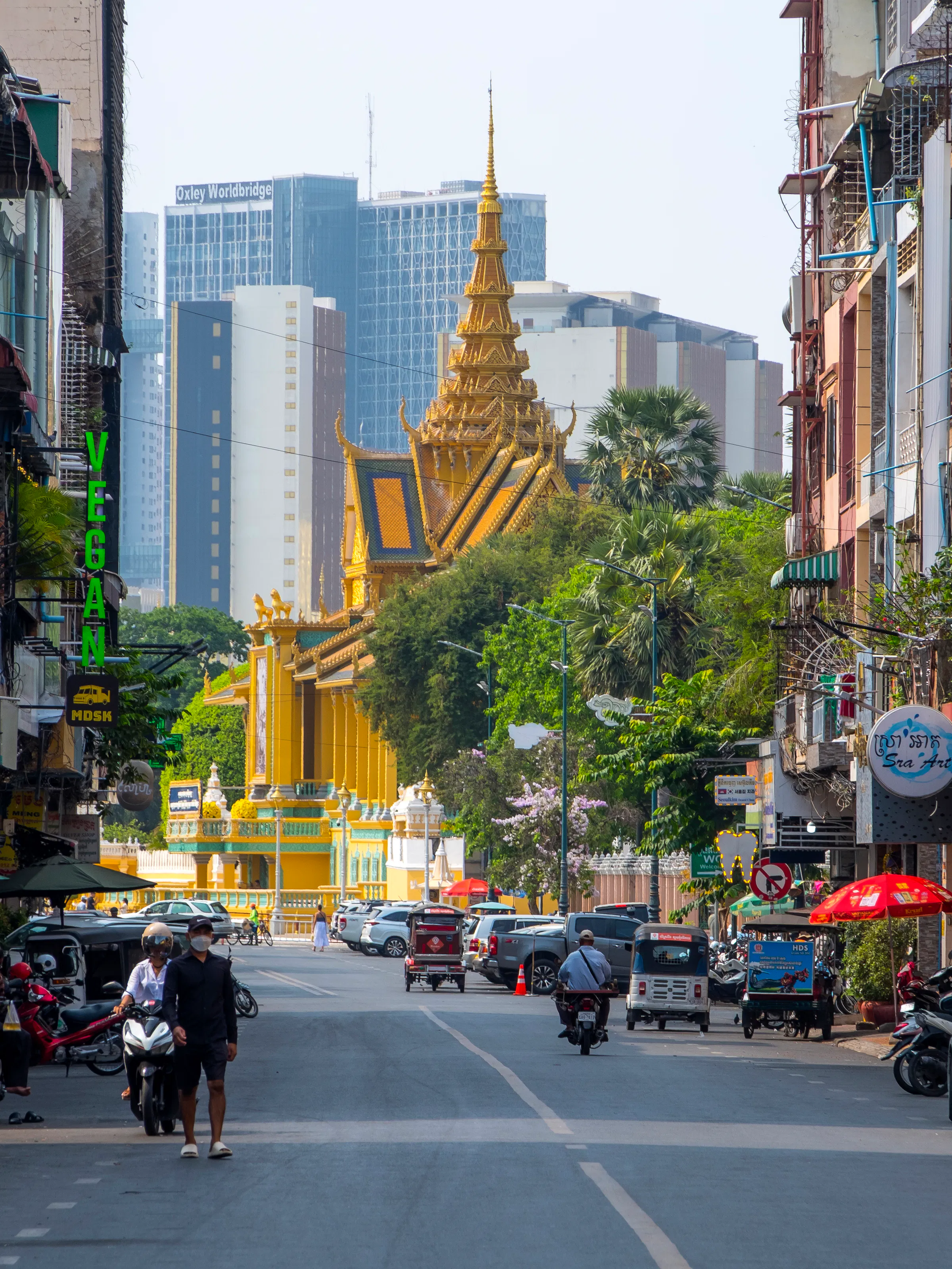 Bustling street with golden Royal Palace spire, Phnom Penh Cambodia