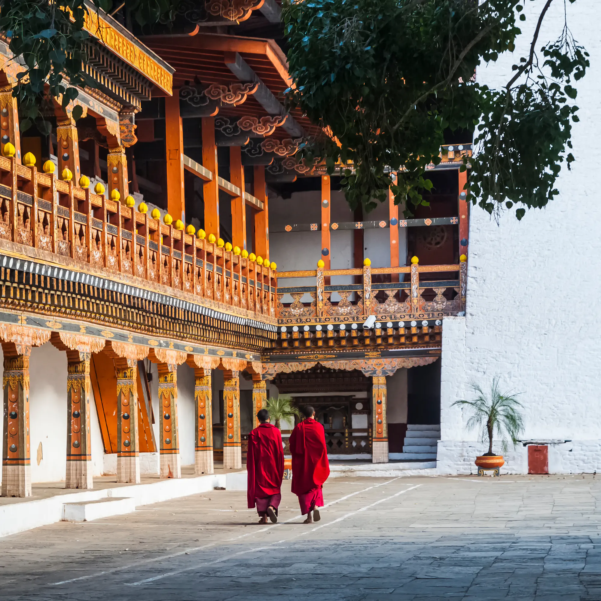 Two monks walking through ornate Punakha Dzong courtyard, Bhutan