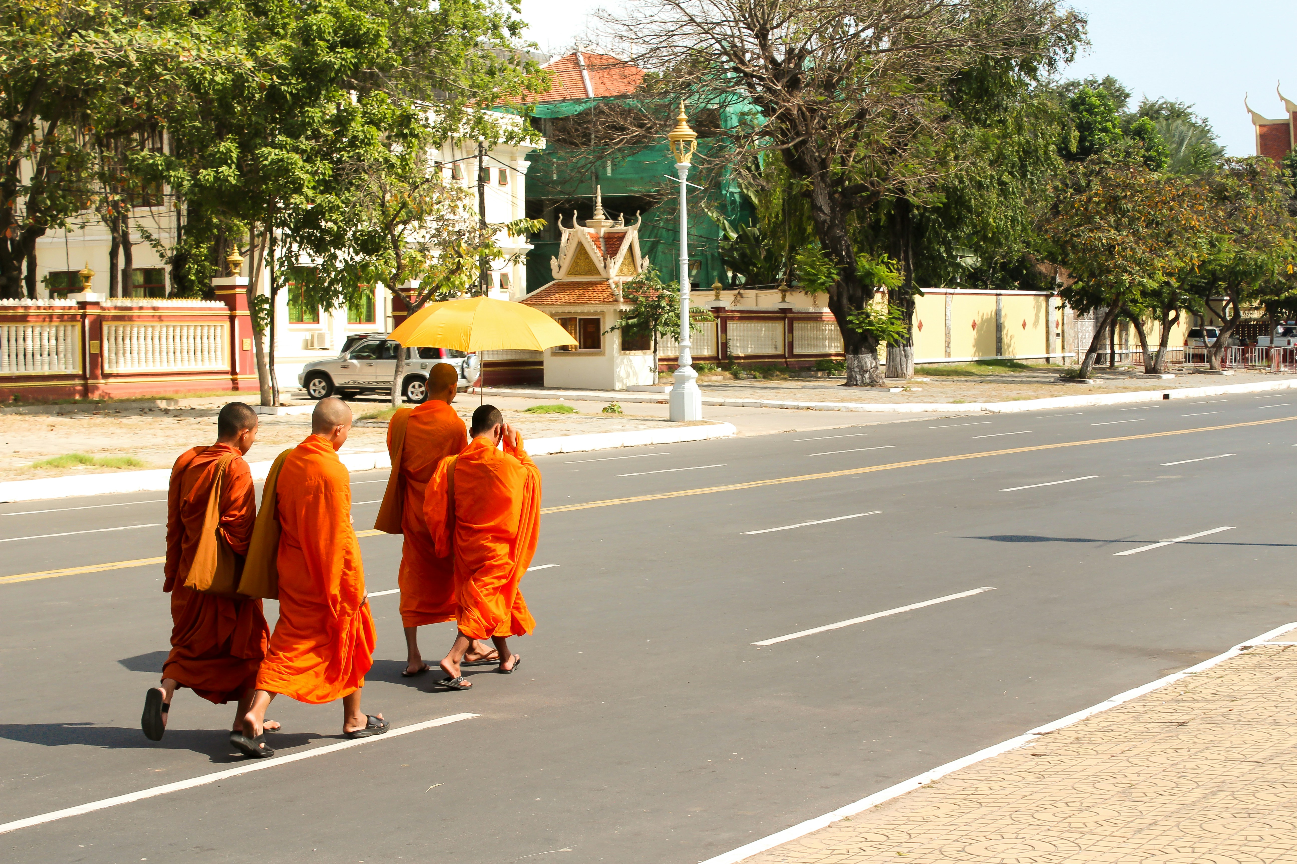 Buddhist monks in orange robes crossing street, Phnom Penh Cambodia