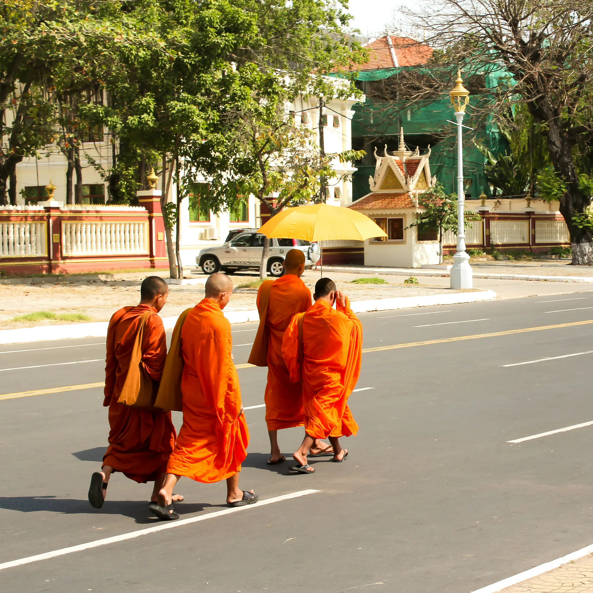 Buddhist monks in orange robes crossing street, Phnom Penh Cambodia