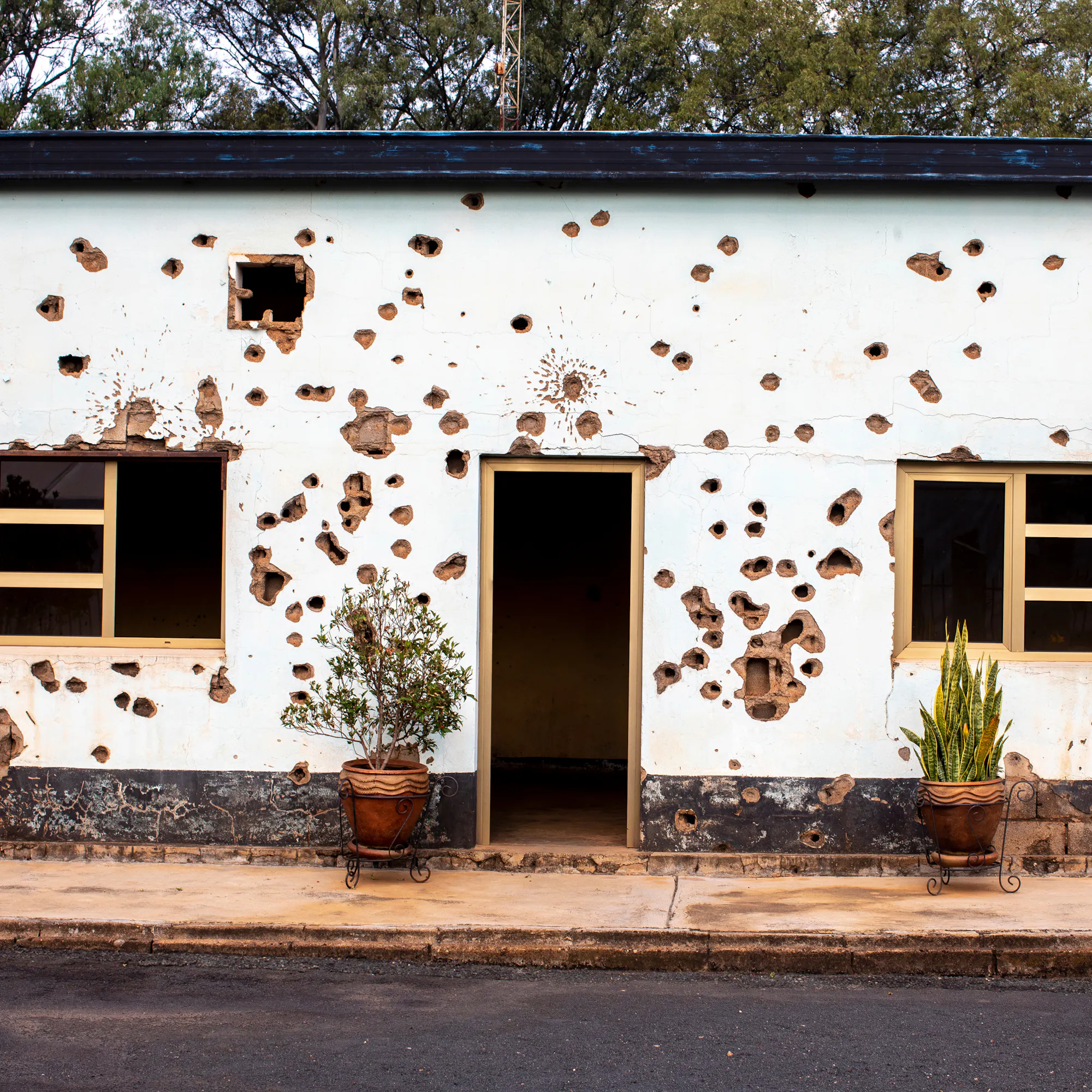 Bullet-scarred wall at the Camp Kigali memorial site in Kigali, Rwanda