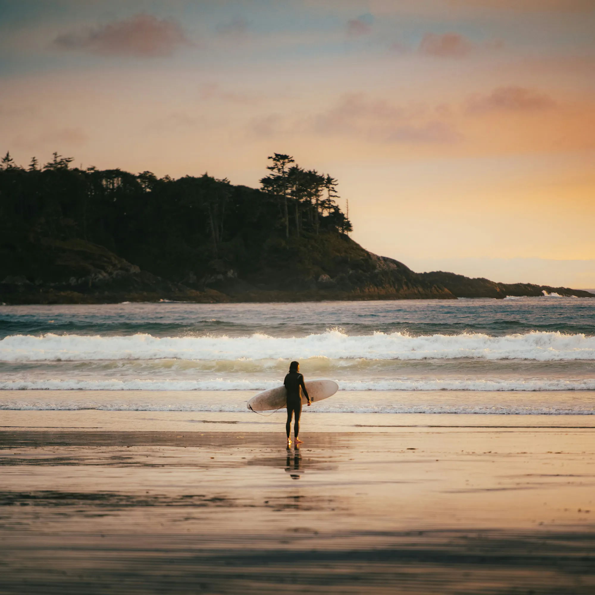 sunset at the beach with a surfer