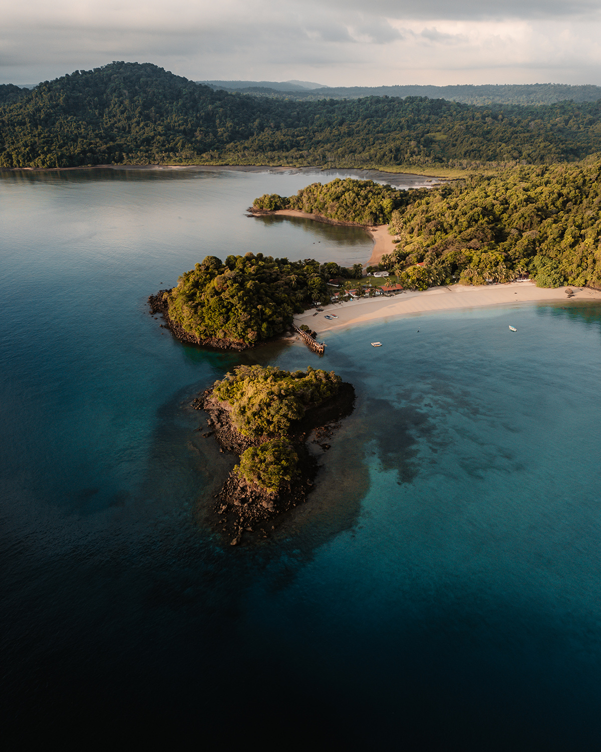 Aerial view of a rainforest coastline with rocky islets and a secluded beach in Panama