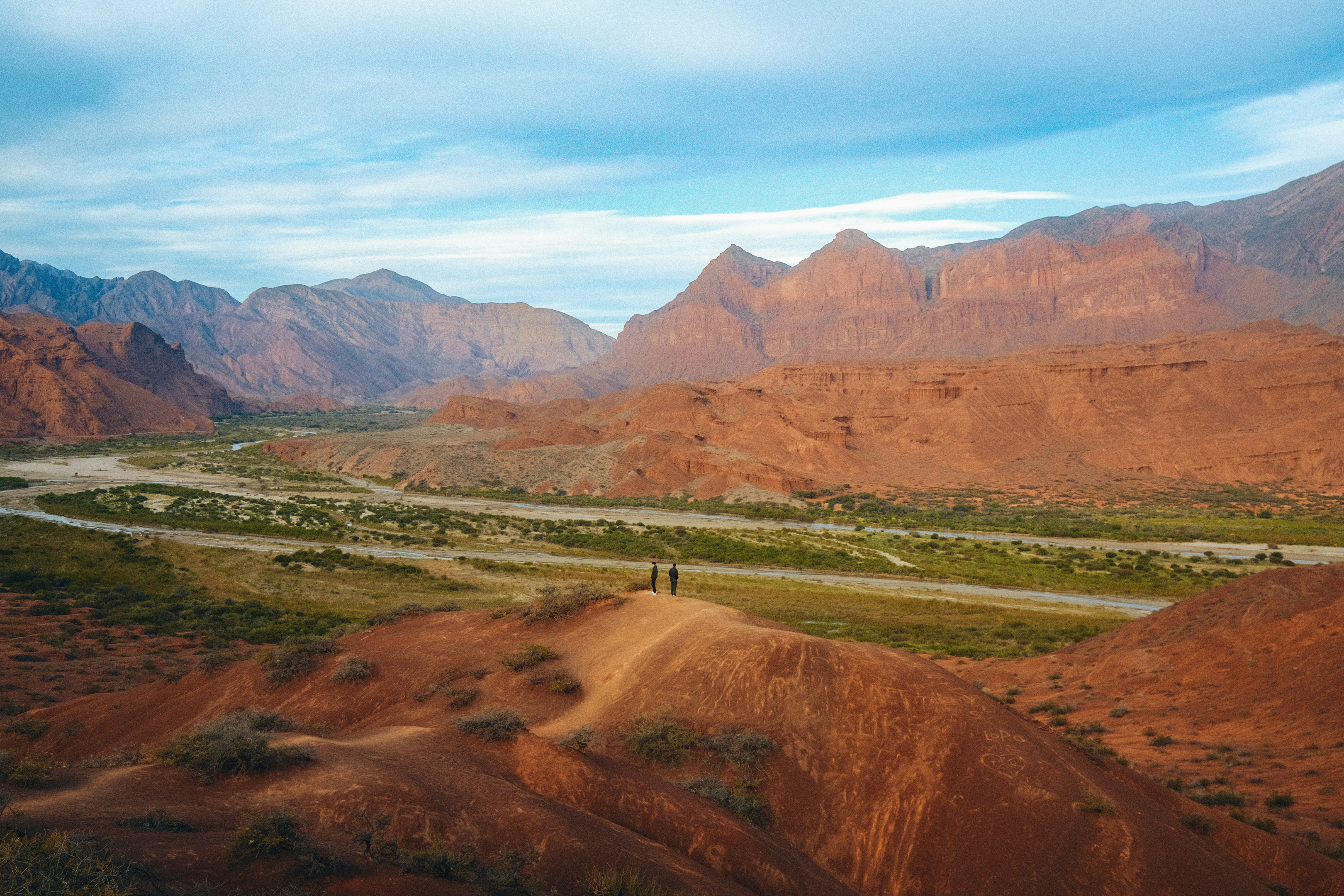 Hikers overlooking red rock canyon in Quebrada de Cafayate, Salta, Argentina