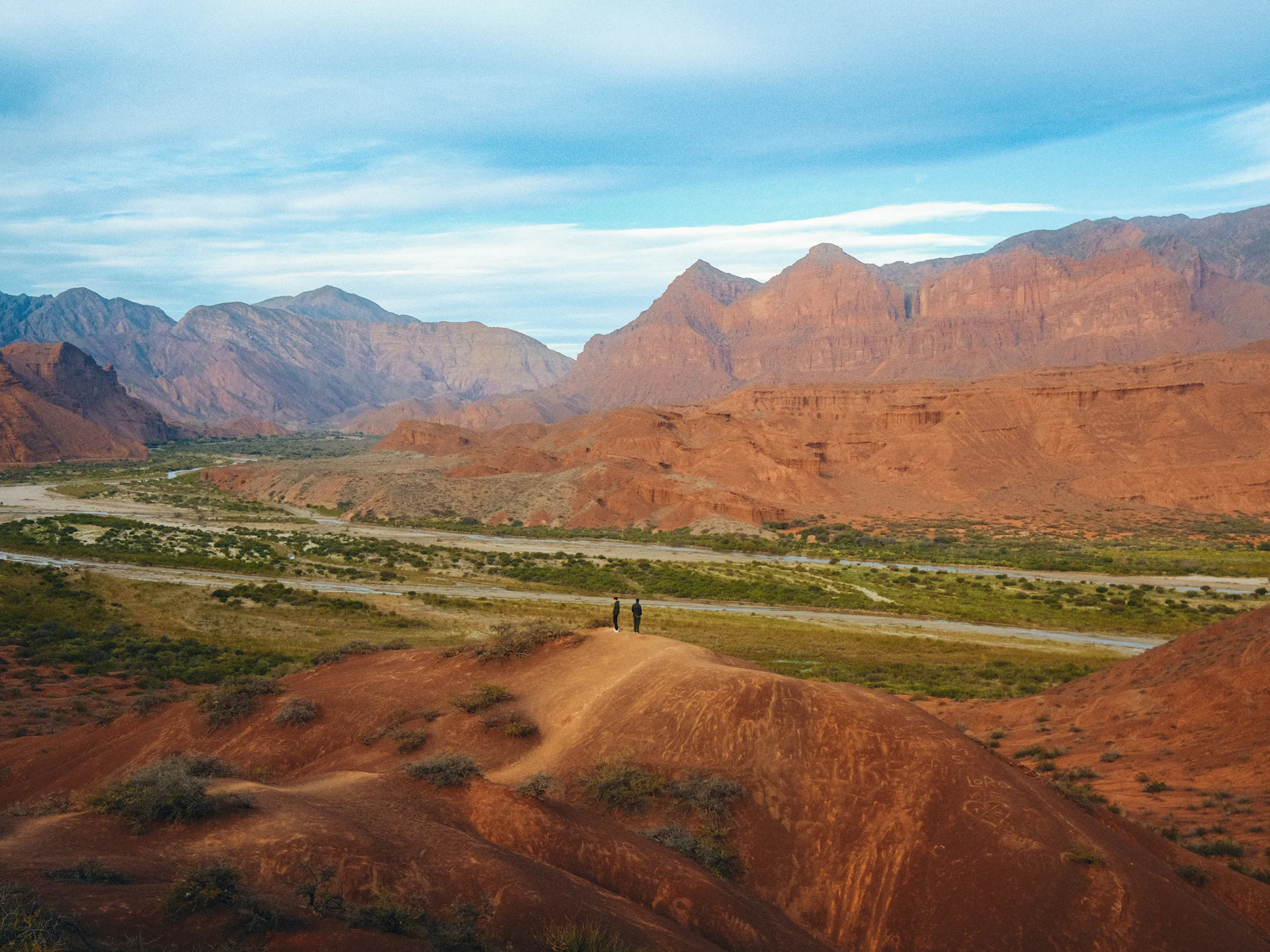 Hikers overlooking red rock canyon in Quebrada de Cafayate, Salta, Argentina