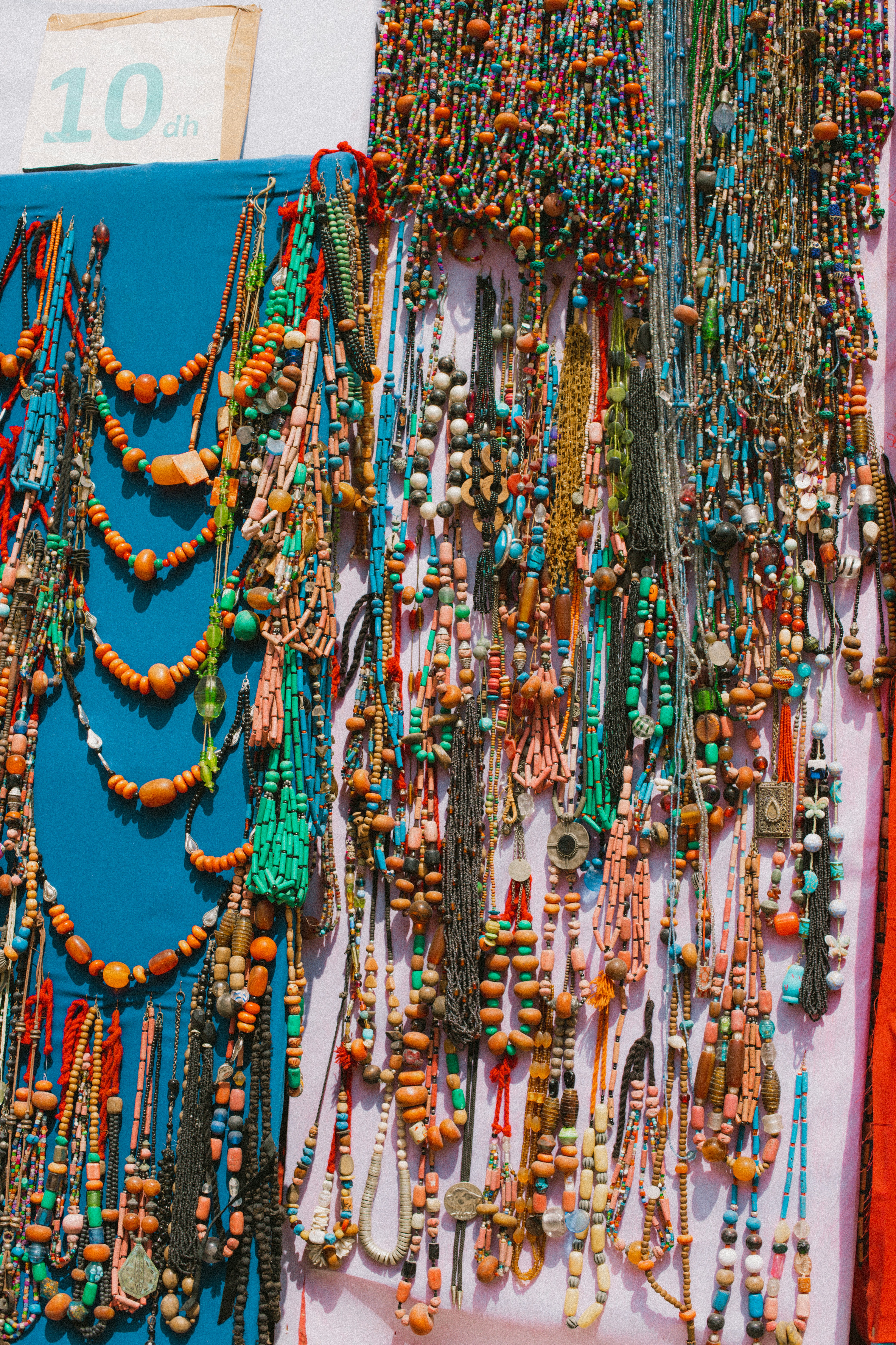 Colorful handmade beaded necklaces for sale at a market stall in Essaouira, Morocco