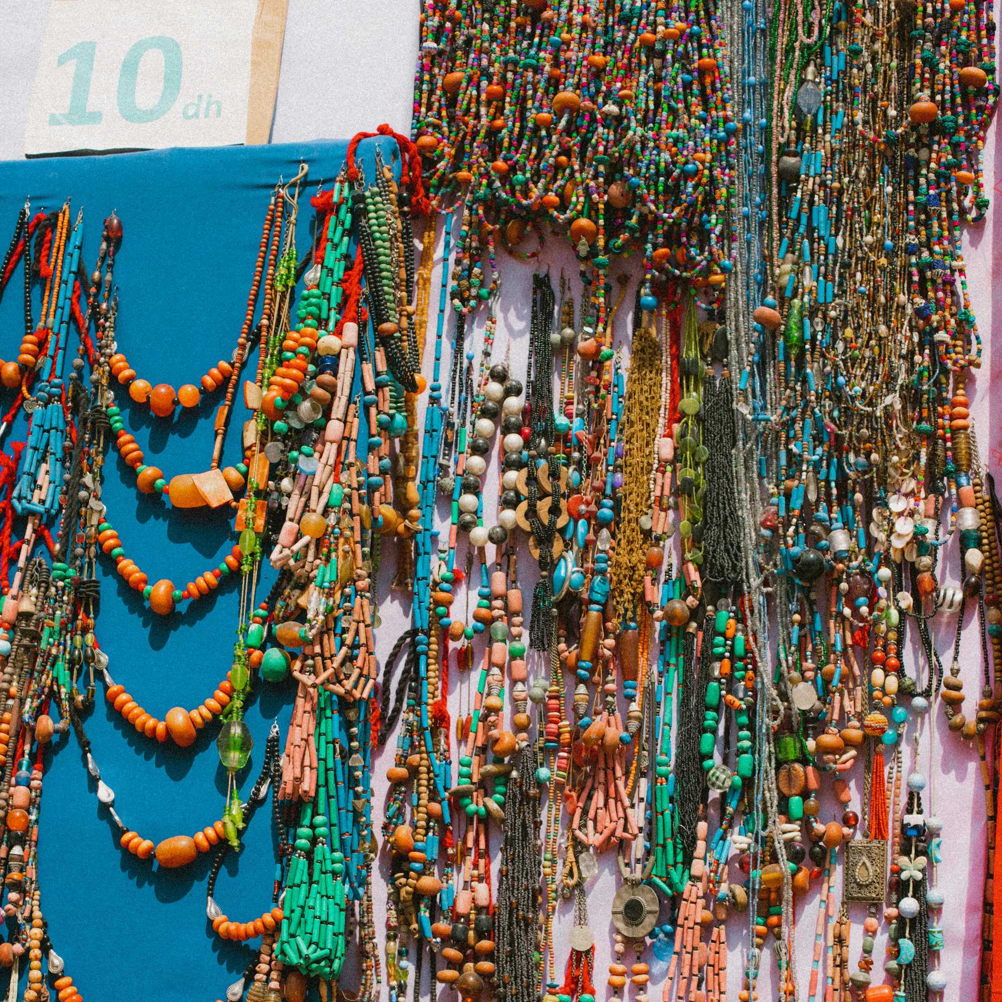 Colorful handmade beaded necklaces for sale at a market stall in Essaouira, Morocco