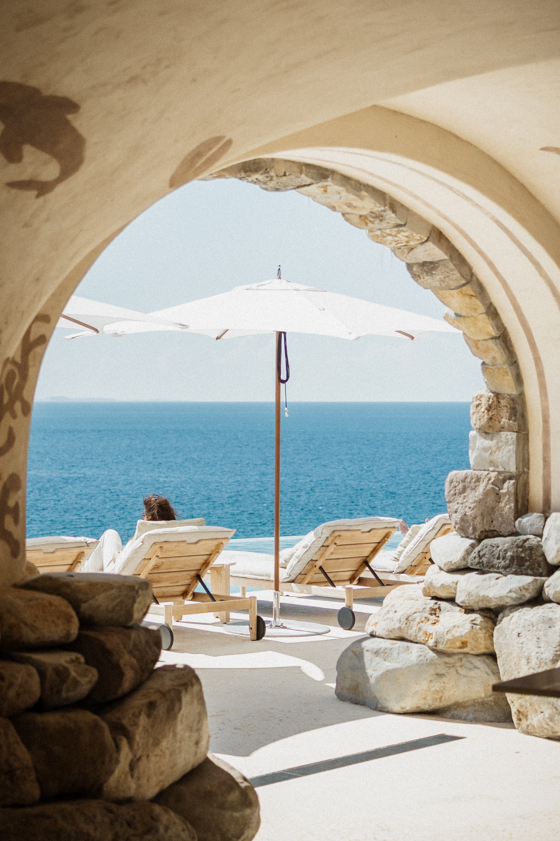 Stone archway framing lounge chairs and an ocean view at Islas Secas, Panama