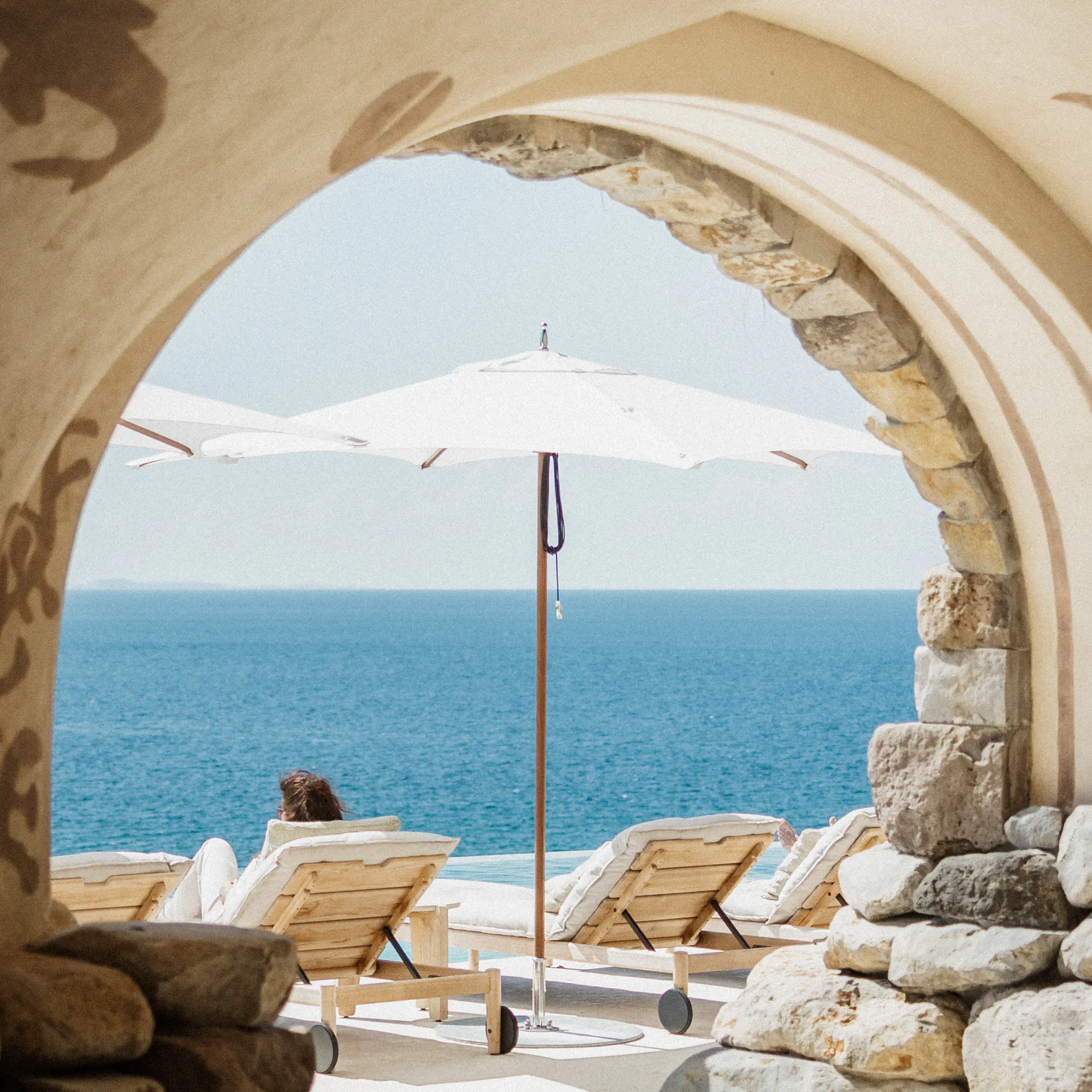Stone archway framing lounge chairs and an ocean view at Islas Secas, Panama